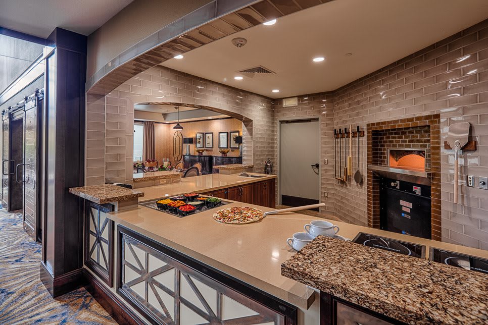 A modern kitchen setup with a pizza oven and preparation area.