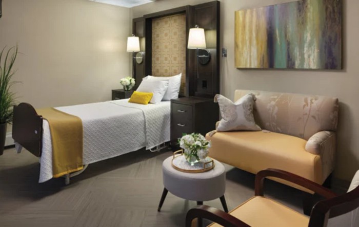 A modern bedroom with contemporary decor, featuring a bed, sofa, and stylish lighting.