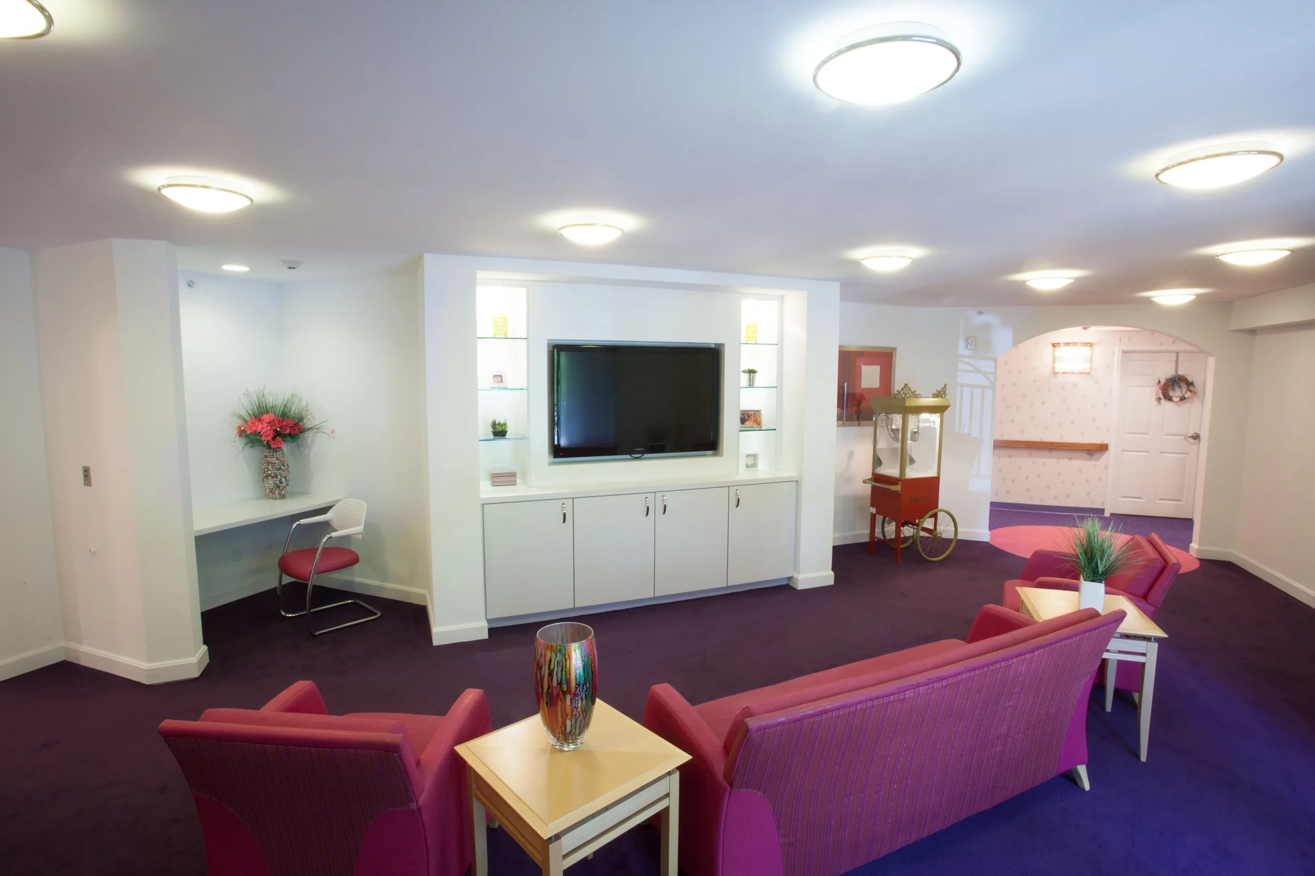 A modern living room with a large television and comfortable seating.