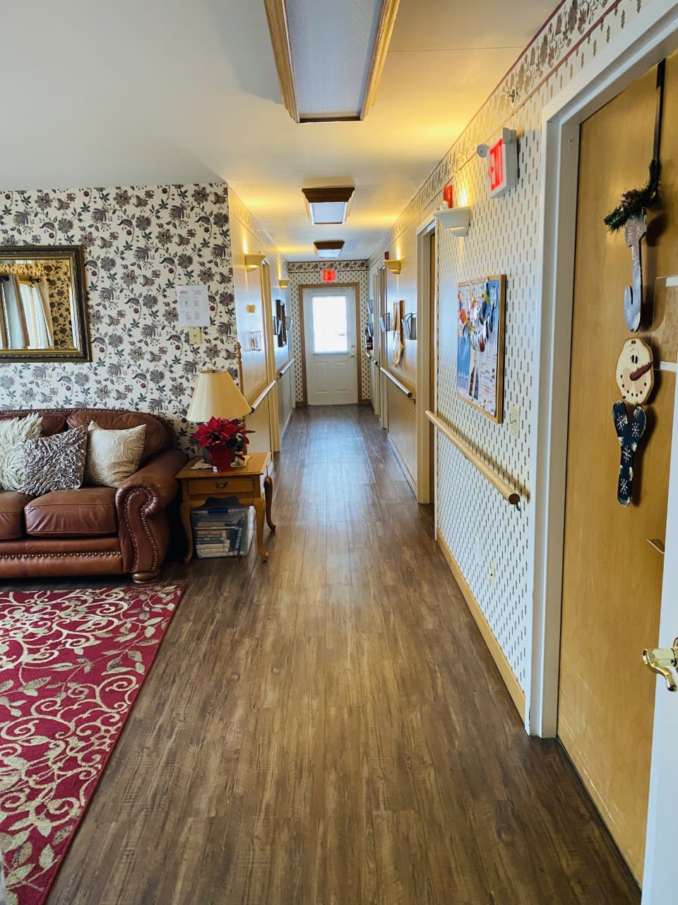 A cozy hallway with a patterned wallpaper, featuring a couch and decorative elements.
