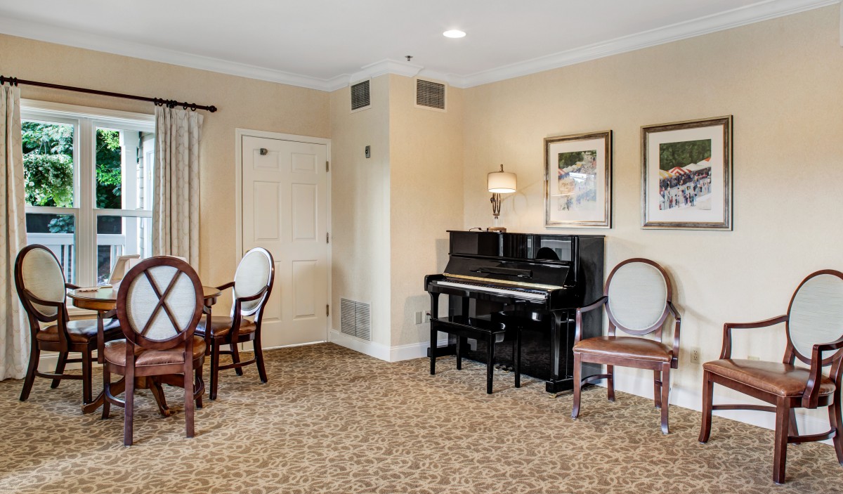 A cozy room featuring a piano and seating areas.