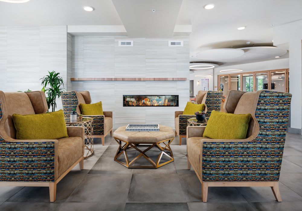 A modern living room with a cozy seating area centered around a stylish fireplace.