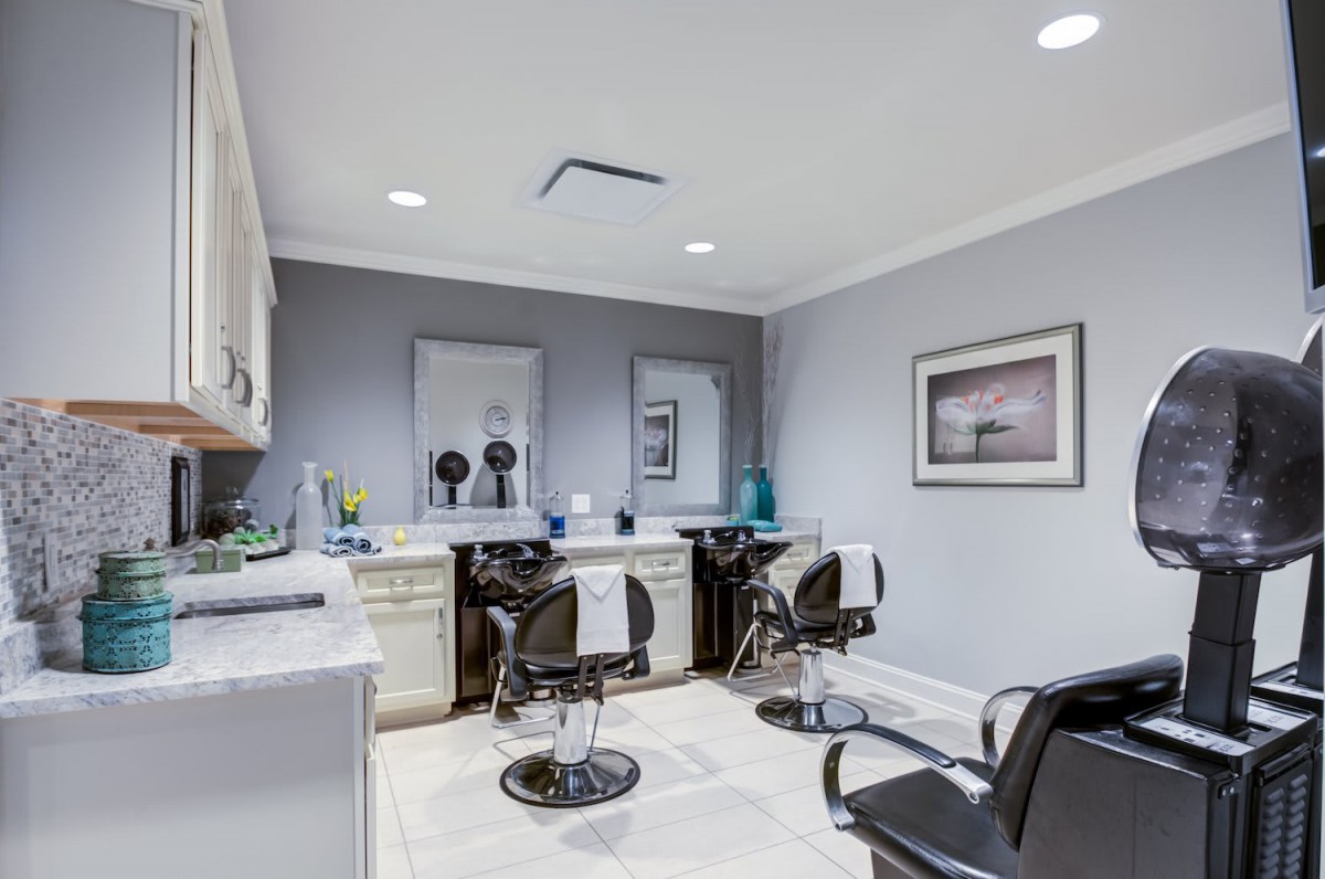 A modern hair salon interior with workstations and mirrors.