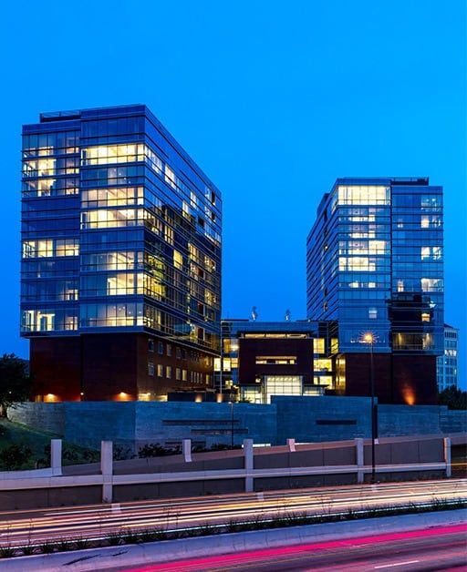 Modern office buildings illuminated at night.