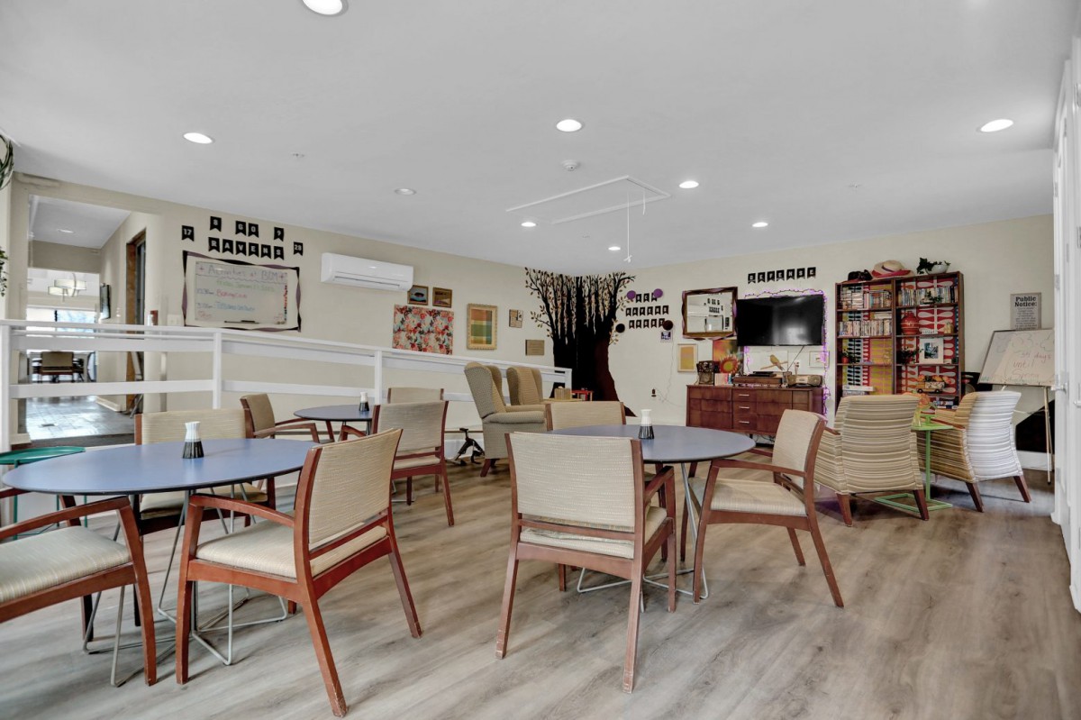 A cozy community dining area with tables and chairs, decorated with memorabilia.