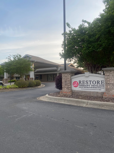 Entrance of the Restore facility showcasing its welcoming sign and well-maintained surroundings.