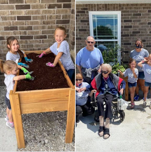 A family enjoys a sunny day working on their raised garden bed together.
