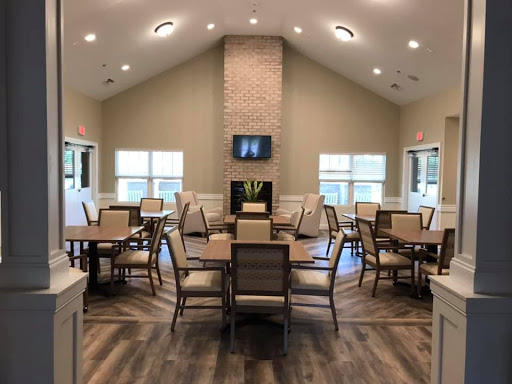 A spacious and modern dining area featuring tables, chairs, and a cozy fireplace.