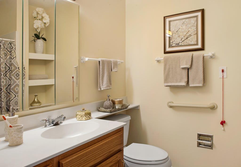 A neatly organized bathroom with a sink, mirror, and towel racks.