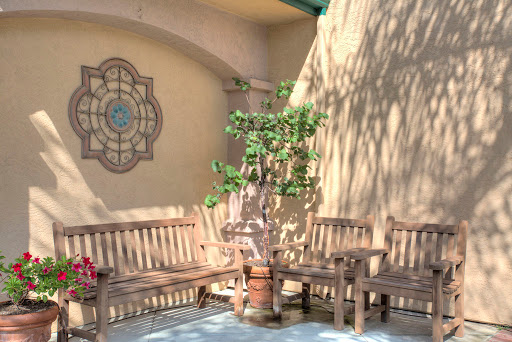A serene outdoor space featuring wooden benches and a decorative wall, perfect for relaxation amidst nature.