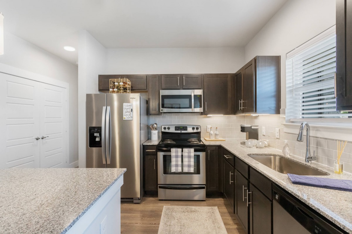 A modern kitchen featuring stainless steel appliances and dark cabinetry.
