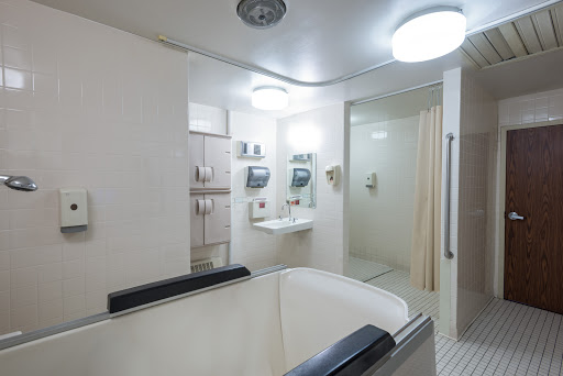A modern and clean bathroom featuring a tub, shower, and ample lighting.