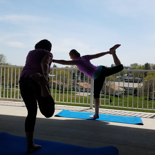 Two individuals practicing yoga outdoors, showcasing strength and balance.