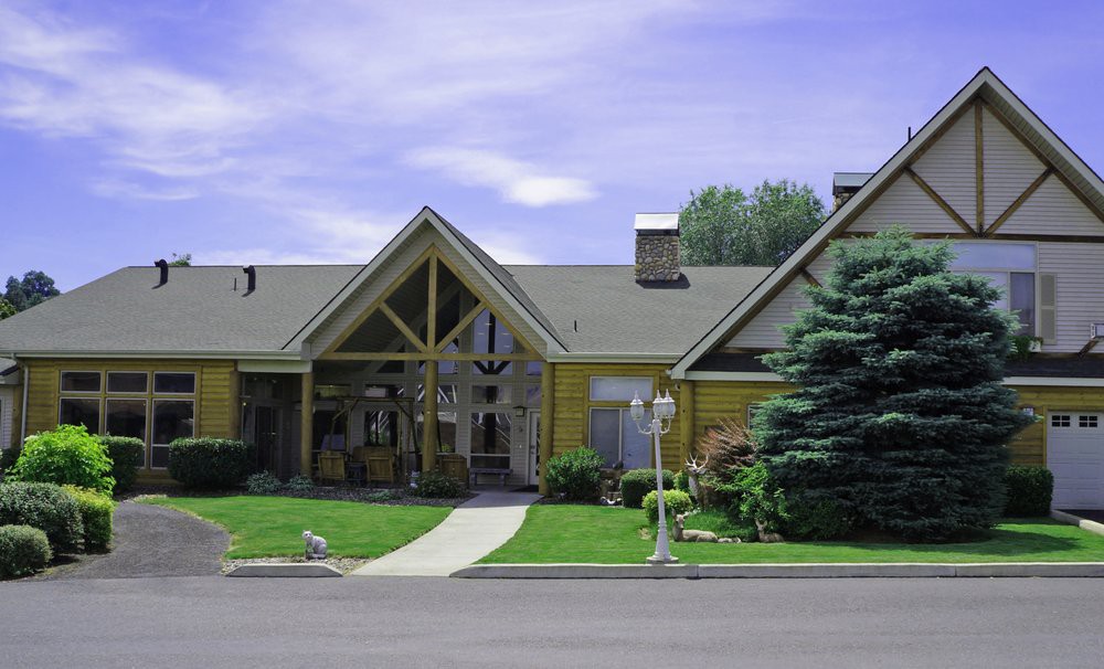 A charming suburban house with a well-maintained lawn and trees.
