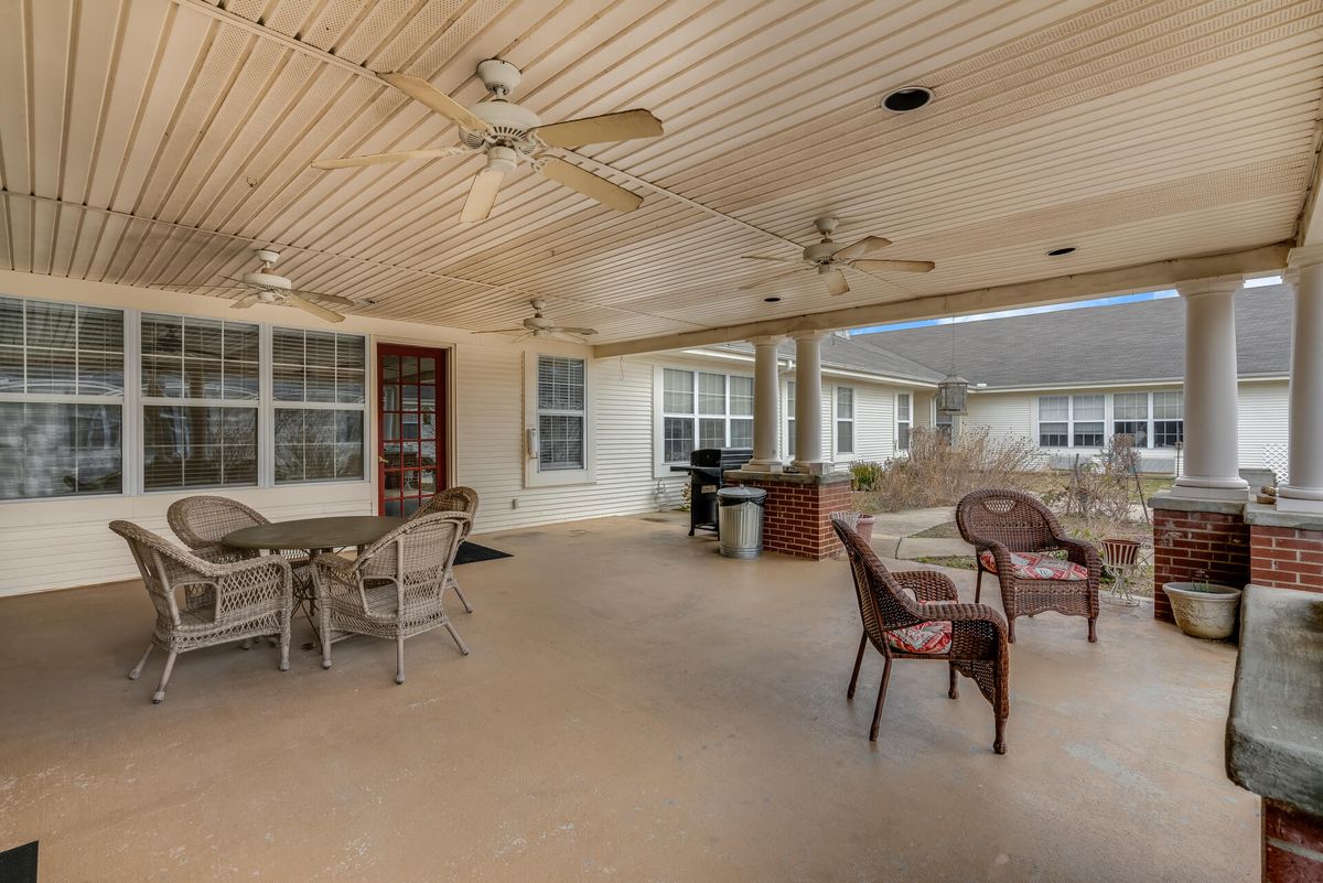 A spacious covered patio with outdoor seating and ceiling fans.