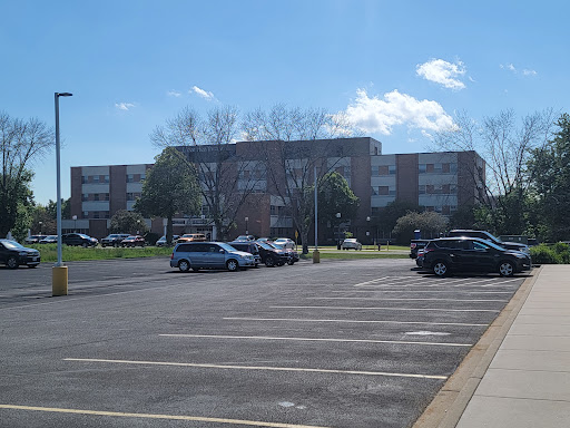 A sunny day with a view of a parking lot and a nearby building.
