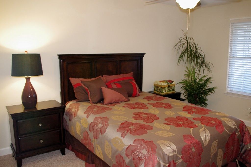A cozy bedroom with a floral bedspread and warm lighting.