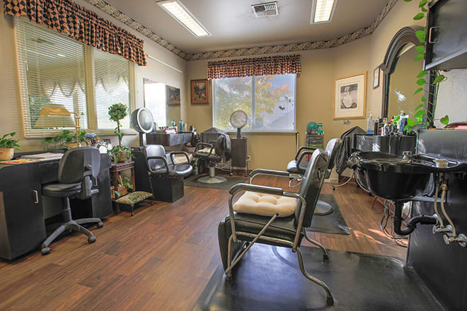 A cozy hair salon interior featuring several styling chairs and mirrors.
