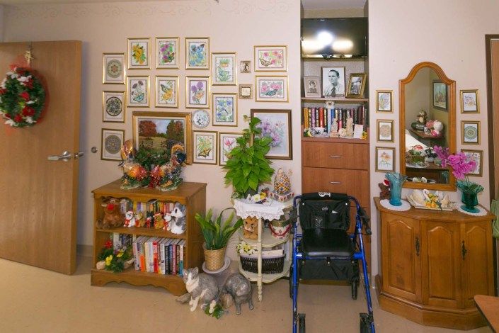 A cozy living room with wall art, a bookshelf, and a walker.