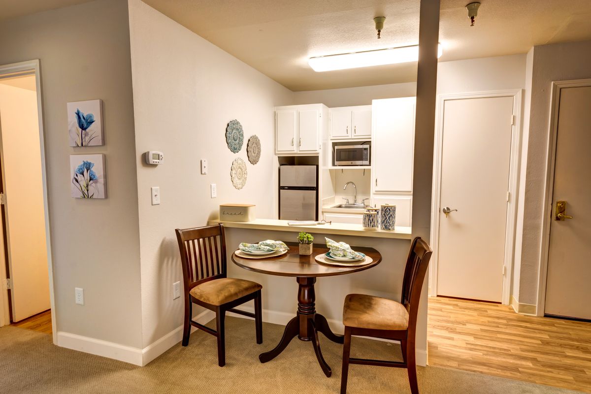 A cozy dining area in a compact kitchen with a small round table and two chairs.