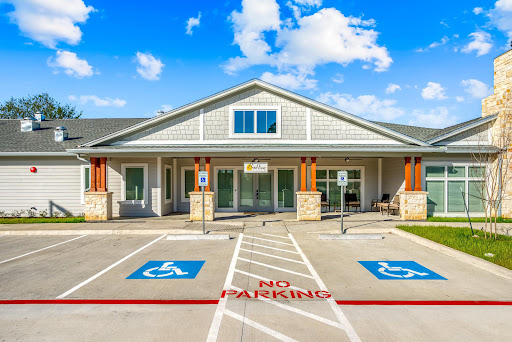 A modern building featuring designated handicap parking and clear signage.