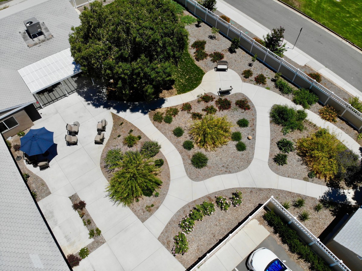 Aerial view of a landscaped garden with winding walkways and various plants.