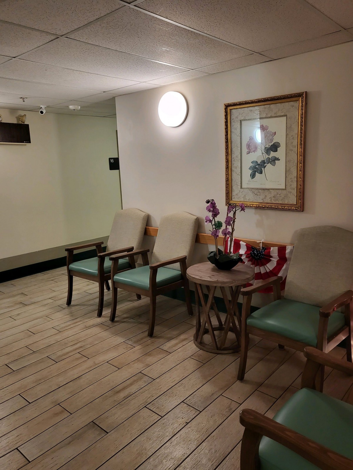 A cozy waiting area with chairs, a table, and artwork on the wall.