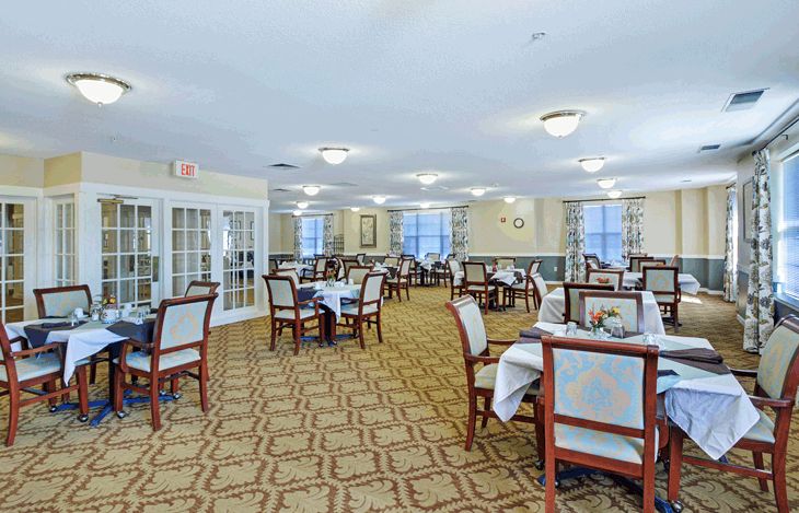 A spacious dining room with neatly arranged tables and chairs, featuring elegant decor and ample lighting.