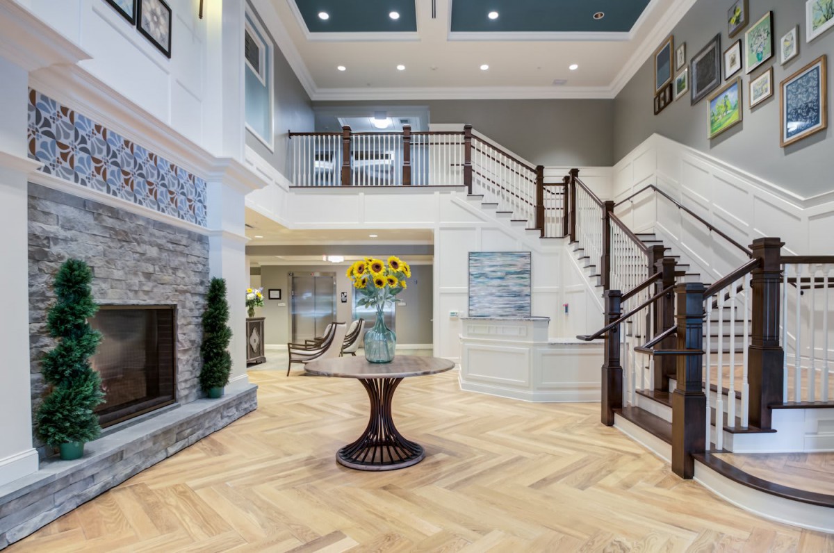 A modern lobby interior with a central staircase and stylish decor.