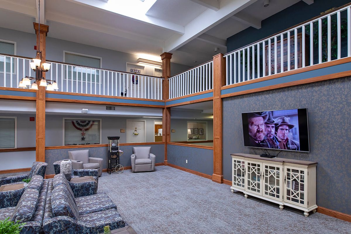 A spacious two-story living area with comfortable seating, a large television, and natural light from a skylight.