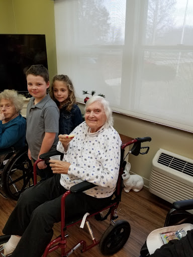 A heartwarming moment shared between children and elderly residents at a care facility.