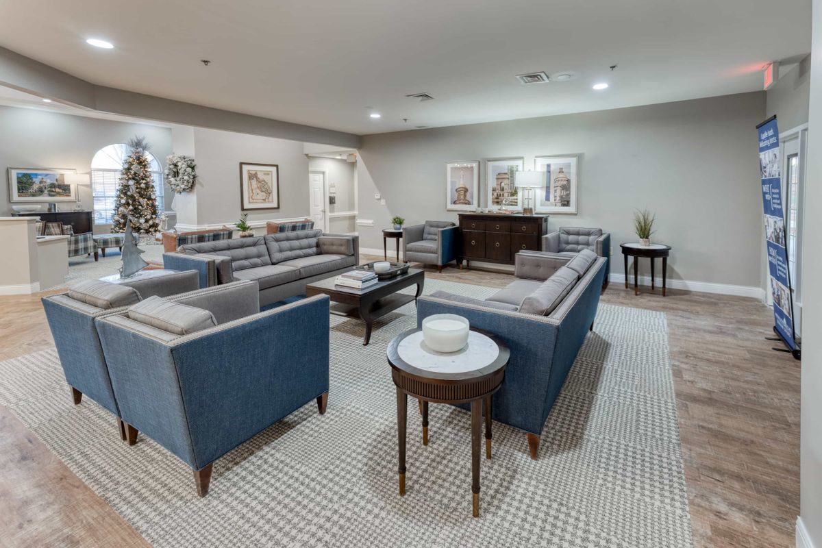 A modern living room with blue sofas and stylish decor.