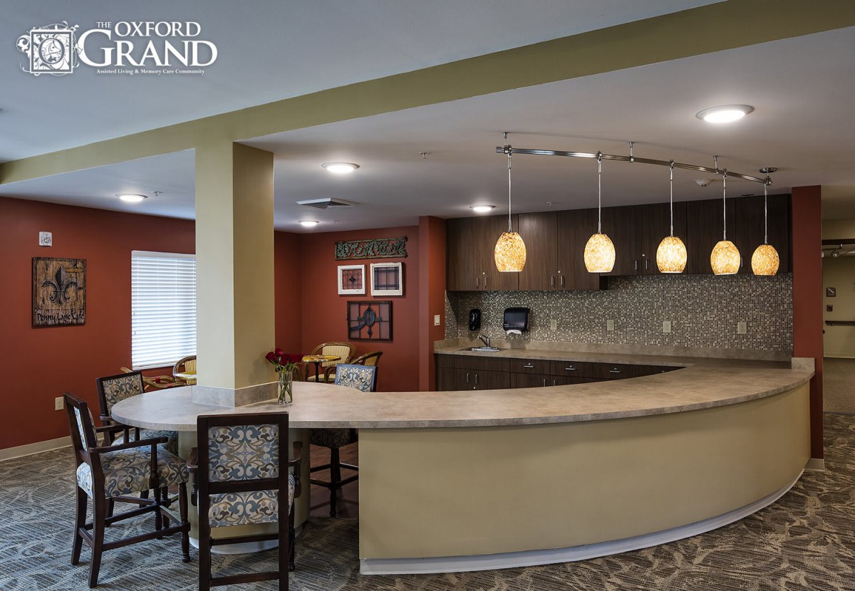A modern kitchen with a curved counter and pendant lighting.