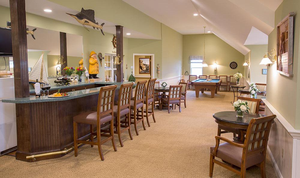 A cozy interior with a bar and seating area, featuring warm lighting and elegant decor.