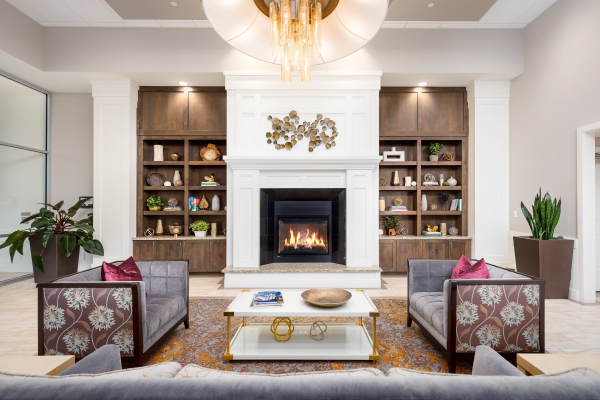 A modern living room featuring a cozy fireplace, elegant bookshelves, and stylish furniture.