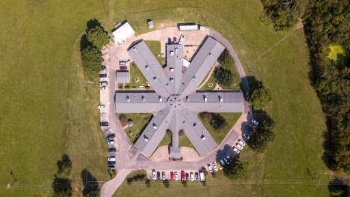 Aerial view of a unique architectural facility surrounded by greenery.