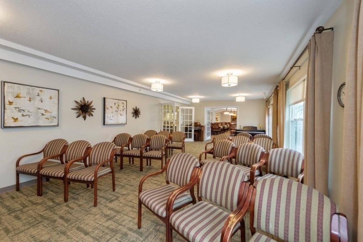 A well-lit waiting or meeting room with rows of striped chairs arranged neatly.