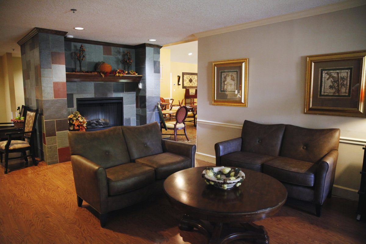 A cozy living room with a fireplace, leather sofas, and a coffee table.