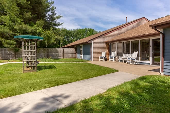 A cozy backyard with a well-maintained lawn and a patio area featuring outdoor seating.