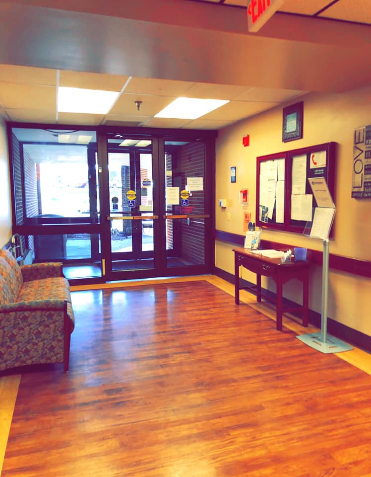 A cozy lobby area with a couch and informational displays near the entrance.