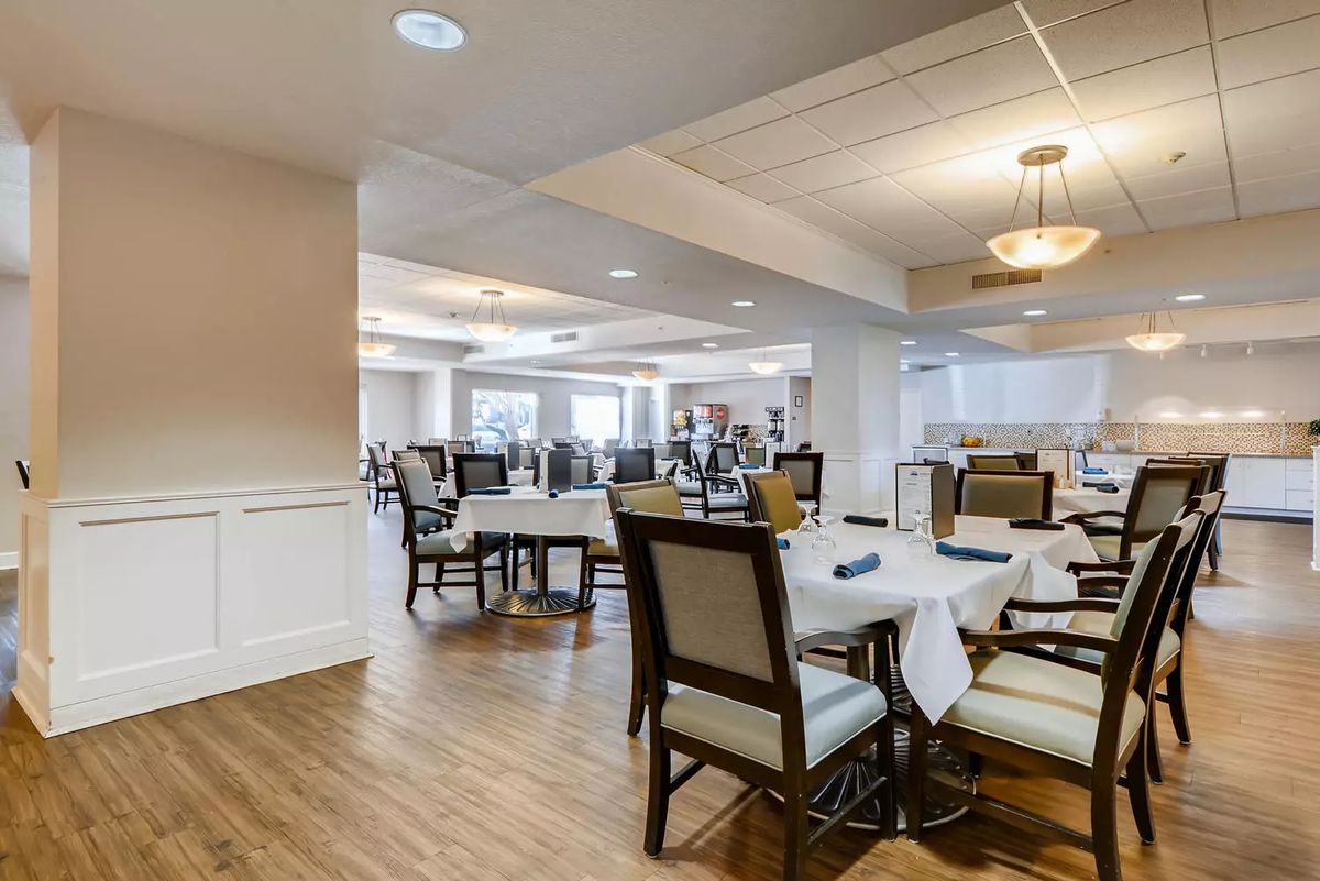 A spacious dining area with neatly arranged tables and chairs, featuring elegant interior design and lighting.