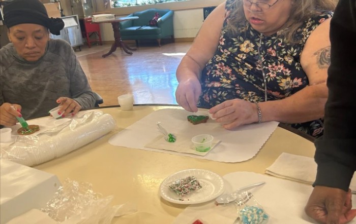 A person engaged in a crafting workshop, carefully working with materials at a table.