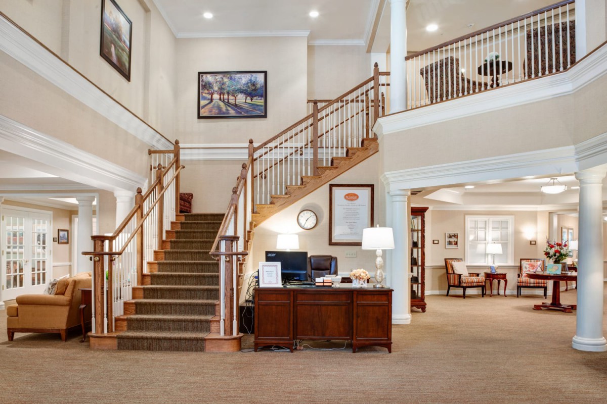 Modern office interior with a grand staircase and reception desk.