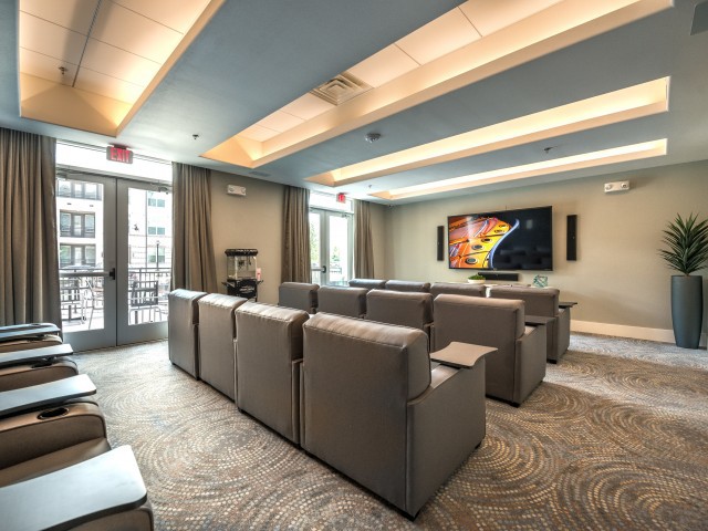 A modern home theater with comfortable recliner seating and a large screen.