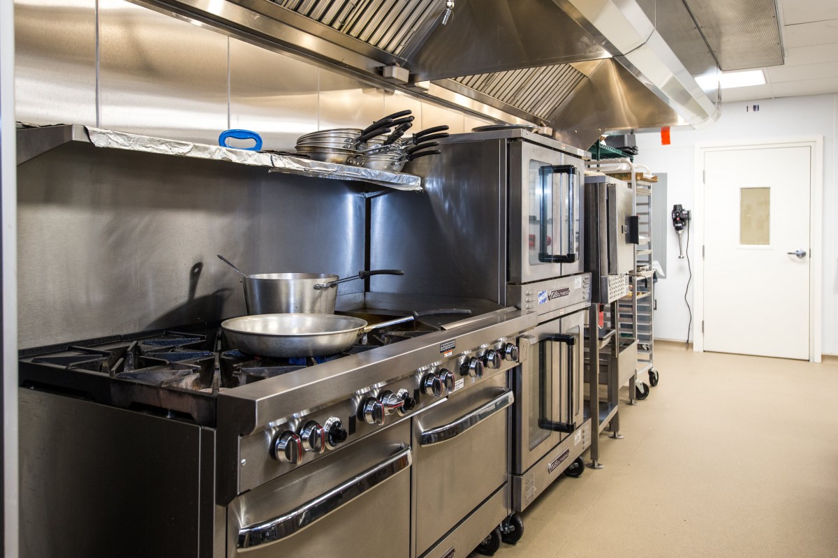 A well-equipped commercial kitchen with stainless steel appliances and cooking equipment.
