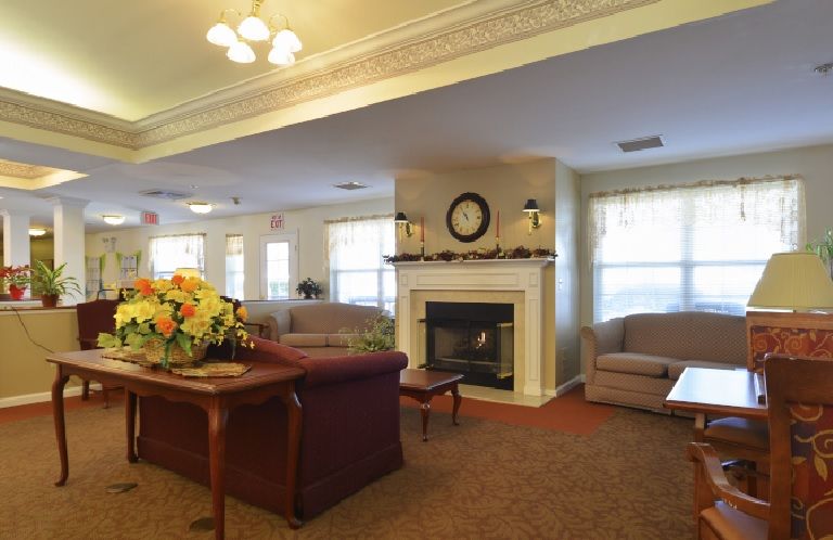 A cozy living room with a central fireplace and comfortable seating.