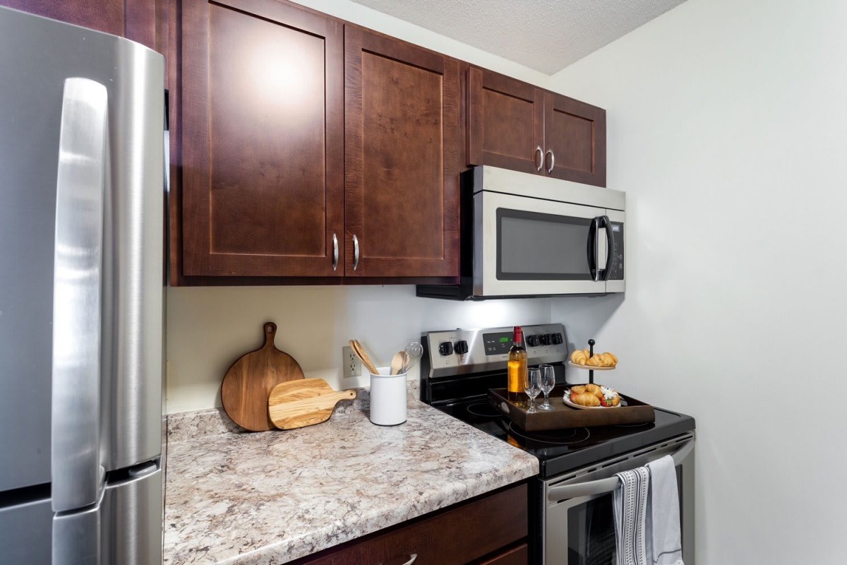 Modern kitchen with dark wood cabinets and stainless steel appliances.