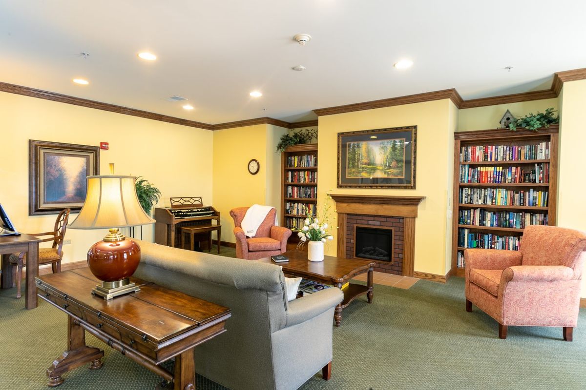 A cozy living room with a fireplace, bookshelves, and comfortable seating.