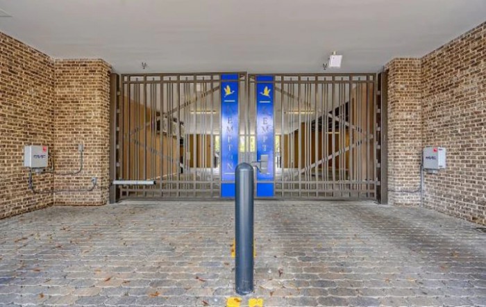 A secured metal gate at the entrance of a parking garage.