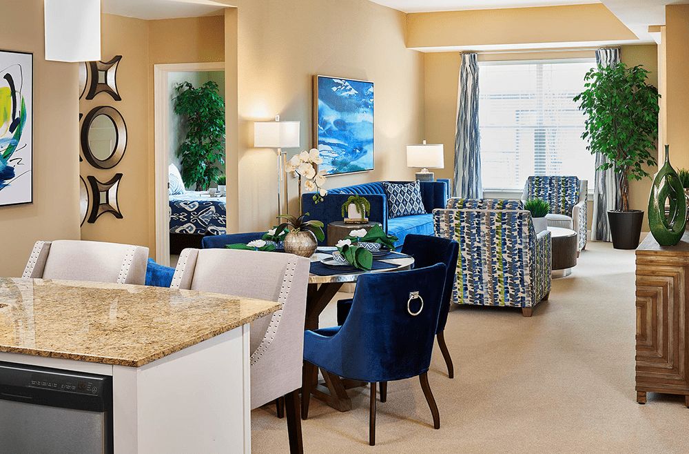 A stylish open-concept living and dining area featuring modern furniture and vibrant blue accents.